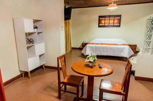イキトスにあるHotel Oro Verde & Suitesのベッドルーム1室(ベッド1台、テーブル、椅子付)