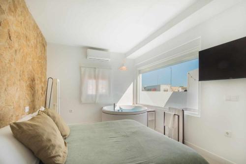 um quarto com uma cama, uma janela e um lavatório em Jacuzzi Amanecer de Plata Decoración Romántica em Chiclana de la Frontera