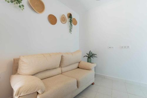 a living room with a couch and hats on the wall at Jacuzzi Amanecer de Plata Decoración Romántica in Chiclana de la Frontera