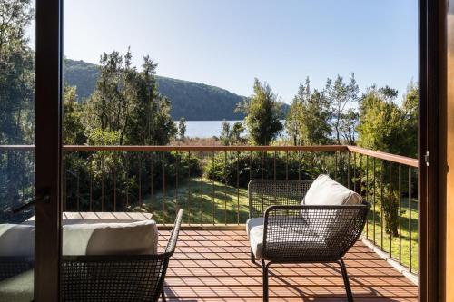 a balcony with chairs and a view of a lake at Casas Martín Pescador, Lago Huillinco, Chiloe in Chonchi