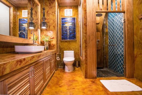 a wooden bathroom with a toilet and a sink at Andalay Beach Resort Koh Libong in Ko Libong