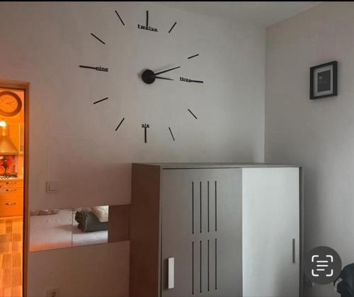 a clock on a wall above a cabinet in a room at Home Away From Home - New Cosy Apartment Kruge in Zagreb