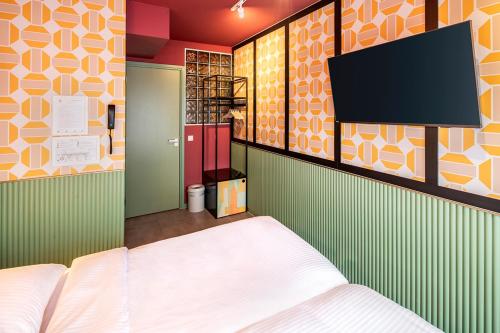 - une chambre avec un lit et une télévision à écran plat dans l'établissement Budget Hotel Tourist Inn, à Amsterdam