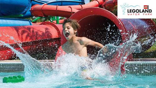 a young boy is playing in a water park at Rove At The Park in Dubai