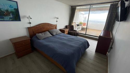1 dormitorio con cama y vistas al océano en Departamento Reñaca, Sector 5, en Viña del Mar