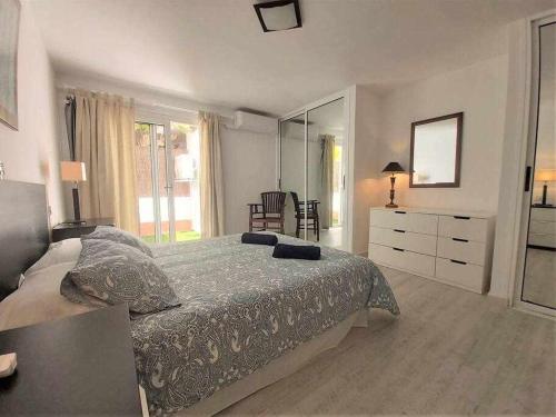 a bedroom with a bed with a dresser and a mirror at BREEZE VIEW house by the sea in Corralejo