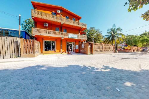 an orange building on the side of a street at Hummingbird Home Suites in San Pedro