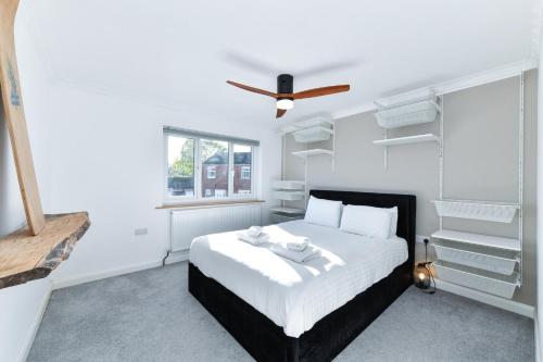 a white bedroom with a bed and a ceiling fan at Morgan House- 4 Bed House, Near Nottingham Trent Uni in Nottingham