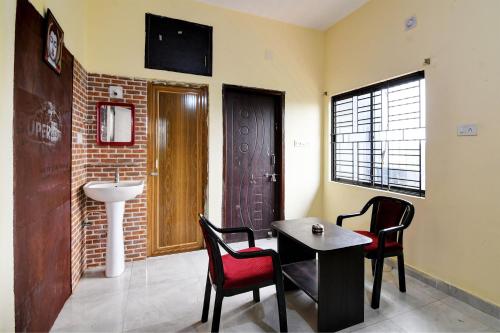 a room with a table and chairs and a sink at OYO Flagship Royal A Palace in Bhubaneshwar