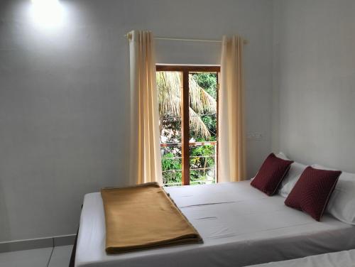 a bed in a room with a window at KOVIL home's Guest land in Cochin
