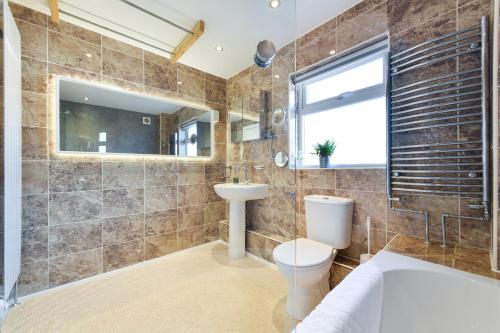 a bathroom with a tub and a toilet and a sink at Morgan House- 4 Bed House, Near Nottingham Trent Uni in Nottingham