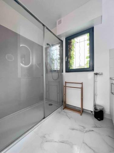 La grande salle de bains est pourvue d'une douche et d'une fenêtre. dans l'établissement Maison indépendante au Croisé Laroche, à Marcq-en-Barœul