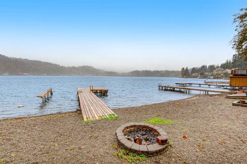 a lake with a wooden pier and a dock at Summit Lake Guesthouse in Kamilche