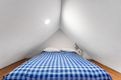 a small bedroom with a blue and white checkered bed at Summit Lake Guesthouse in Kamilche