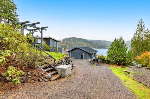 a house on the shore of a body of water at Summit Lake Guesthouse in Kamilche
