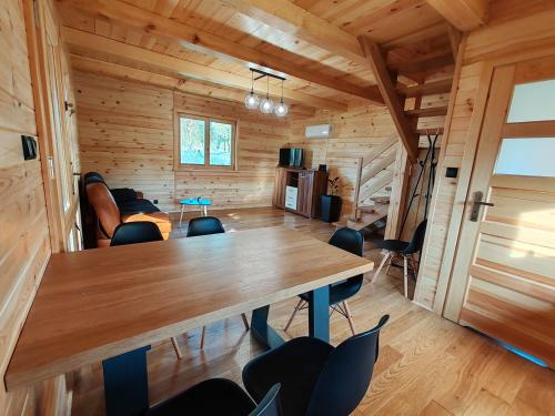 ein Esszimmer mit einem Holztisch und Stühlen in der Unterkunft BAJKA-Domek na wsi in Domaszków