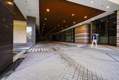 a person walking down a hallway of a building at The Radiance Manila Bay Studio in Manila