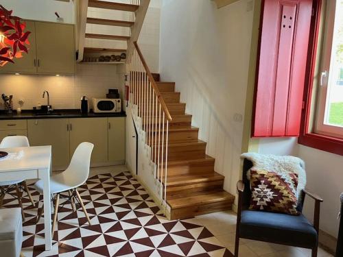 托馬爾的住宿－Casinha de Sao Gião，厨房设有楼梯、桌子和椅子