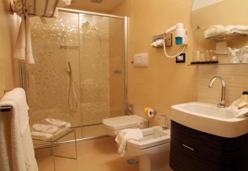 ein Bad mit einer Dusche, einem Waschbecken und einem WC in der Unterkunft Hotel Cenacolo in Somma Vesuviana