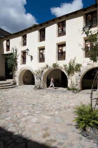 a person sitting in the courtyard of a building at Hotel Manantial in Caldes de Boi