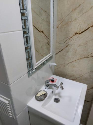 La salle de bains est pourvue d'un lavabo blanc et d'un miroir. dans l'établissement Maria y Carlos Departamento 5 personas independiente cerca de Viña del Mar, à Villa Alemana
