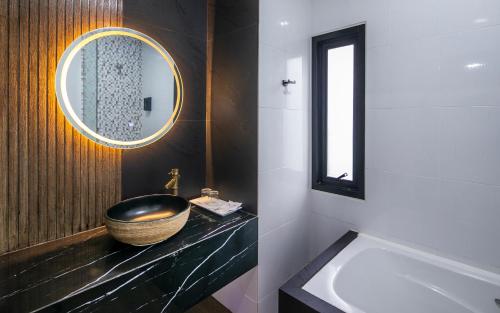 a bathroom with a bowl sink and a mirror at Tuana Hotels The Phulin Resort in Karon Beach