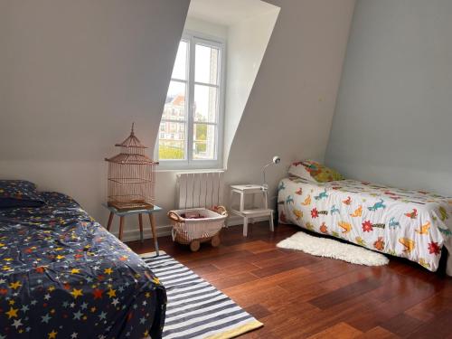 a bedroom with a bed and a crib and a window at L'ART in Chantilly