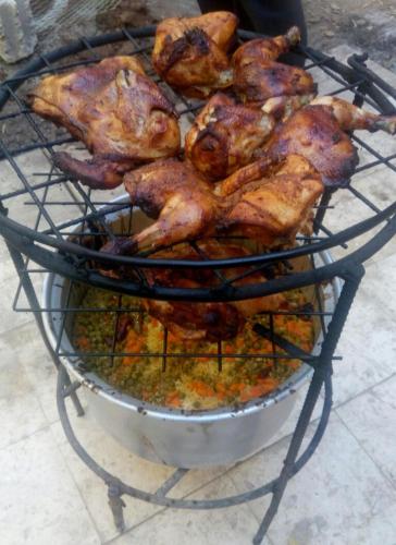 a bunch of chickens are cooking on a grill at Dana Rose camp outdoor camping in Dana