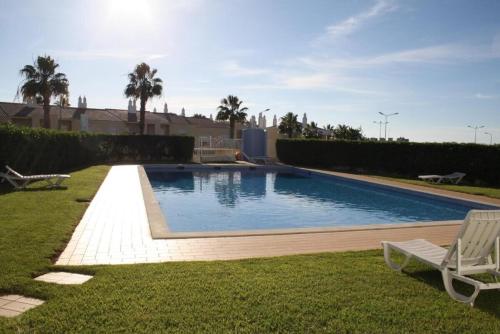 una piscina en un patio con una silla en 4 bedroom town house Vale de Parra, close to Gale AT22, en Guia