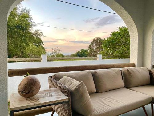 a living room with a couch and a table on a porch at Sea La Vie - Holiday Home in Albion