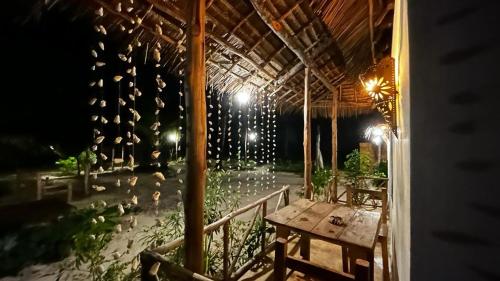 een patio met een tafel en een bos vogels bij Stonefish Inn Jambiani in Jambiani