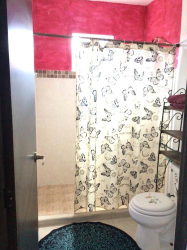 a bathroom with a toilet and a shower curtain at Mar y Luna in Mérida