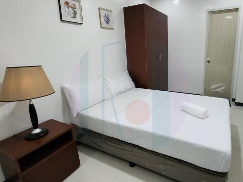 - une chambre avec un lit et une lampe sur une table de chevet dans l'établissement RiCres Hometel Standard R5, à Babak