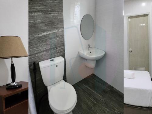 - deux photos d'une salle de bains avec toilettes et lavabo dans l'établissement RiCres Hometel Standard R5, à Babak