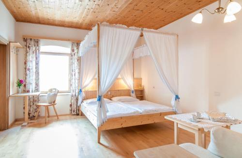 1 dormitorio con 1 cama con dosel en Garni Tschutscherhof, en Laion