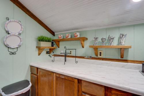 a kitchen with a white counter top and wooden cabinets at Bunkhouse-Style Studio in Elkins Near ATV Trails! in Elkins