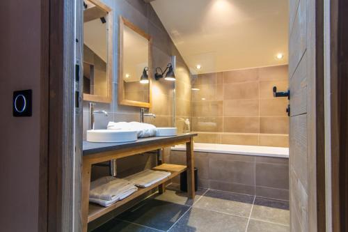 a bathroom with a sink and a bath tub at Hôtel de la Roche in Beaufort