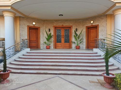 a set of stairs with wooden doors and potted plants at Paradise Studios in Sheikh Zayed