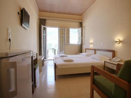 a hotel room with a bed and a kitchen and a room at Ionis Hotel in Agios Nikitas