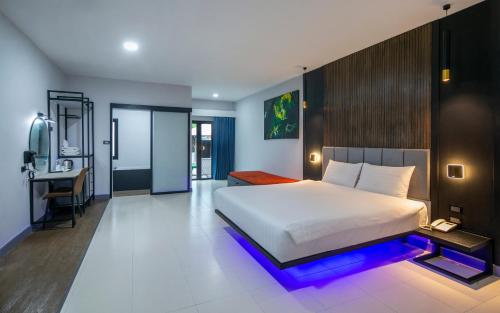 a bedroom with a bed and a desk in it at Tuana Hotels The Phulin Resort in Karon Beach