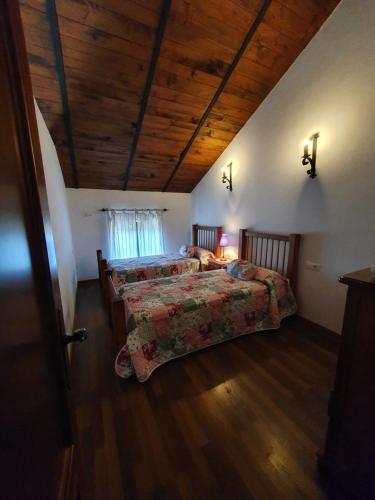 um quarto com 2 camas e um tecto de madeira em Las Cuevas de El Bosque em El Bosque