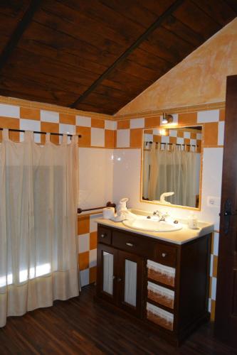 uma casa de banho com um lavatório e um espelho em Las Cuevas de El Bosque em El Bosque