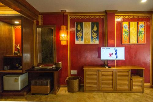 a living room with a television on a wooden cabinet at Andalay Beach Resort Koh Libong in Ko Libong