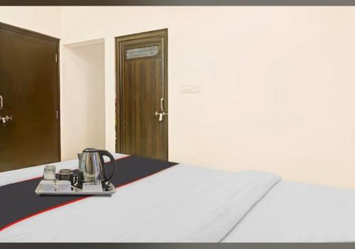 Hotel Sanwariya Residency في أودايبور: غرفة بها سرير وغلاية شاي