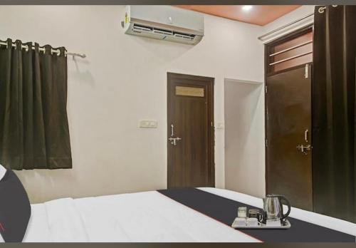 a bedroom with a bed and a mirror and a door at Hotel Sanwariya Residency in Udaipur