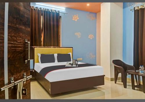 Hotel Sanwariya Residency في أودايبور: غرفة نوم بسرير مع كرسي وطاولة