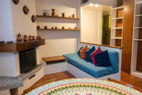 a living room with a blue couch with pillows on it at 181 - Casa Arcobaleno tra le Alpi, Piste da sci a 15 minuti in Castione della Presolana