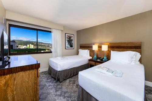 ein Hotelzimmer mit 2 Betten und einem Fenster in der Unterkunft Ocean Front Spectacular Condo in Honolulu