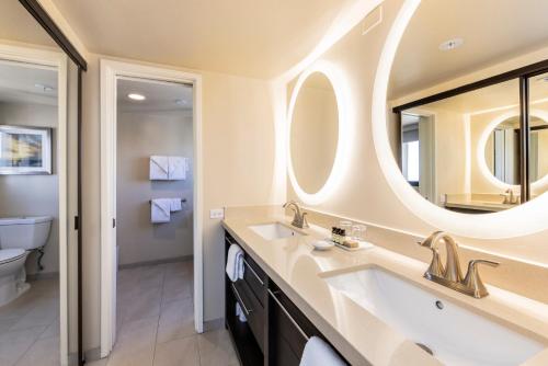 a bathroom with a sink and a mirror at Ocean Front Spectacular Condo in Honolulu