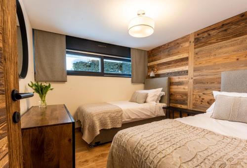 a bedroom with two beds and a window at Ashmour Alpine in Les Gets